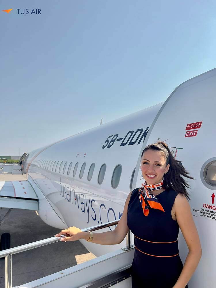 TUS Airways flight attendant smiling
