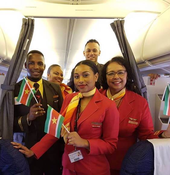 Surinam Airways male and female flight attendants flag