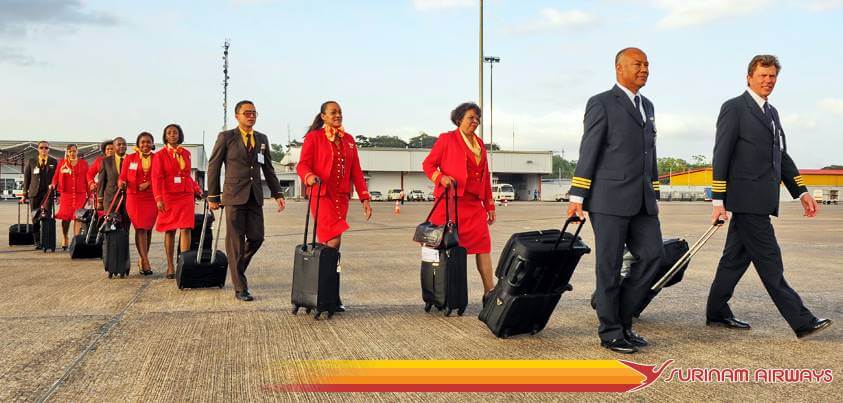 Surinam Airways pilots and cabin crews walk